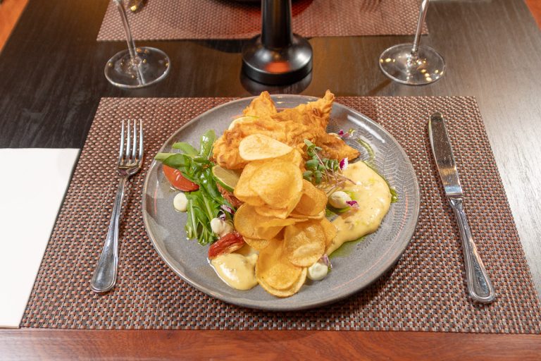 Fish and Chips: Pesca del día en tempura crocante, acompañada de mayonesa cítrica de pepinillos y papas crocantes.